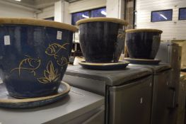 Three blue glazed earthenware pots with stands.