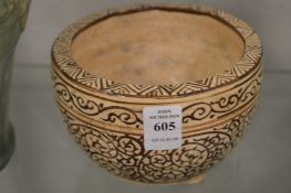 A Chinese pottery bowl with scrolling decoration.