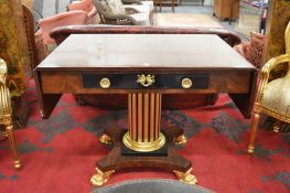 A good Empire style mahogany and parcel gilded sofa table with a drawer to each side on a fluted