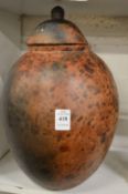 An African mottle brown glazed earthenware jar and cover.