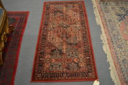 A small Persian style machine made rug, 158cm x 80cm.