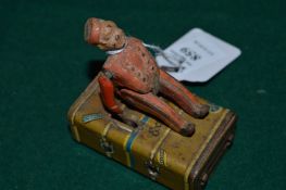 A small tin plate toy modelled as a boy and a trunk.