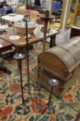 A wrought iron candle stand and graduated set of three others.