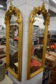 A pair of gilt wood arch shaped decorative wall mirrors.