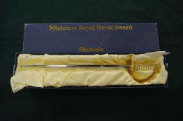 A miniature sword, boxed.
