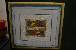A Hebrew textile, framed and glazed.