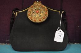 A black fabric evening bag, the decorative clasp combined with a small mirror.