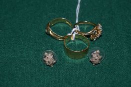 Gold and yellow metal rings and a pair of ear studs.