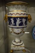 An impressive large pair of classical style urns decorated with cherubs.