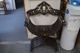 An Italian ebony and ivory inlaid Savonarola X framed armchair, the back panel inset with a portrait