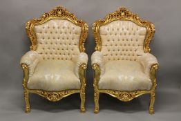 A PAIR OF MODERN GILTWOOD ARMCHAIRS upholstered with a cream damask style fabric.