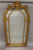 A LARGE GILTWOOD ARCH TOP PIER MIRROR, mounted with cherubs. 7ft 2ins high x 3ft 6ins wide.