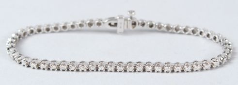 A 9CT WHITE GOLD AND DIAMOND TENNIS BRACELET.