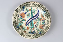 A 19TH CENTURY IZNIK TABAK CIRCULAR POTTERY DISH, painted with stylised flowers. 27.5cms diameter.