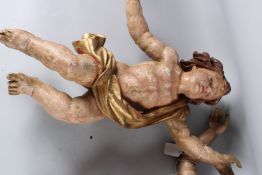 A PAIR OF 18TH CENTURY CARVED WOOD, PAINTED AND GILDED CHERUBS. 50cms long.