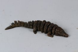 A SMALL BRONZE ARTICULATED MODEL OF A CROCODILE. 19cms long.