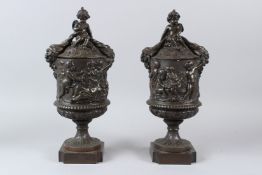 A PAIR OF CLASSICAL STYLE BRONZE URNS AND COVERS, cast with playful cherubs. 38cms high.