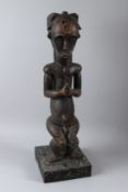 A LARGE CARVED WOOD TRIBAL SEATED FIGURE. 76cms high.