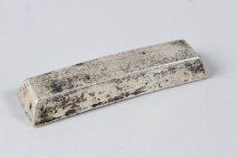 A CHINESE BOAT SHAPED WHITE METAL INGOT. 11cms long.