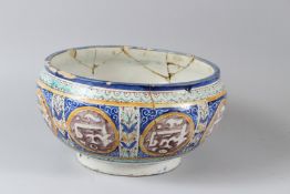 A 19TH CENTURY ISLAMIC POTTERY BOWL, painted with calligraphy panels (faults). 27cms diameter.