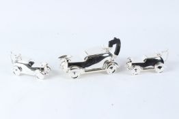 A NOVELTY PLATED THREE PIECE TEA SET, modelled as vintage cars. Largest 25cms long.
