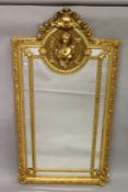 A LARGE DECORATIVE GILTWOOD PIER MIRROR, inset with a bust of a young woman. 6ft 10ins high x 4ft
