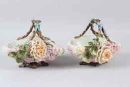 A PAIR OF CONTINENTAL PORCELAIN FLOWER BASKETS, with branch style handles and floral encrusted
