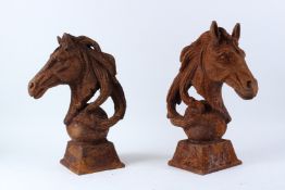 A PAIR OF CAST IRON HORSE HEAD GATEPOST FINIALS. 43cms high.