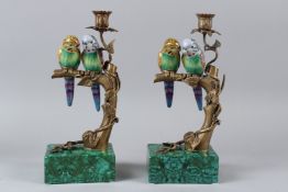 A PAIR OF FAUX MALACHITE, PORCELAIN AND ORMOLU CANDLESTICKS, modelled as budgerigars on a branch.