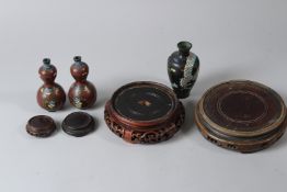A PAIR OF JAPANESE GOURD CLOISONNE VASES, a further cloisonne vase and four Chinese wooden stands.