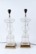A PAIR OF GLASS URN SHAPED TABLE LAMPS, on polished brass bases. 58cms high.