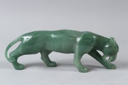 A FABERGE STYLE CARVED JADE MODEL OF A TIGER, with gold and ruby eyes, in a fitted case. 26cms