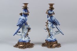 A PAIR OF PORCELAIN PARROT SHAPED CANDLESTICKS with ormolu mounts. 36cms high.