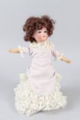 A SMALL VICTORIAN BISQUE PORCELAIN HEADED DOLL. 28cms high.