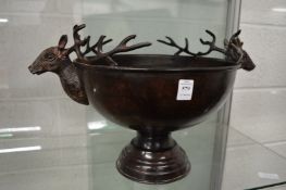 A large pedestal bowl with deer head handles.