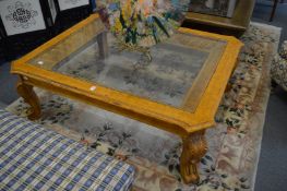 A large carved wood glass top coffee table.