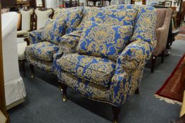 A pair of large horseshoe shaped Victorian style armchairs, upholstered in a classic blue ground
