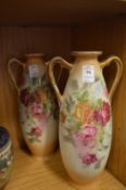 A pair of decorative twin handled vases.