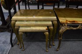 An onyx and brass nest of three tables.