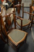 A set of four mahogany dining chairs, one with arms.