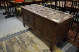 An 18th century oak coffer with carved decoration.