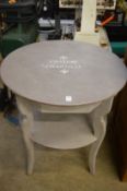 Decoratively painted circular two-tier table.