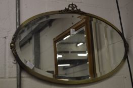 A decorative oval wall mirror.