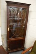A mahogany standing corner cabinet.