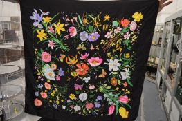 A black silk scarf decorated with flowers and butterflies.