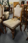 A set of three oak dining chairs with upholstered backs and seats, each bearing a trading label