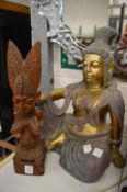A carved wood figure and a resin seated Buddha.