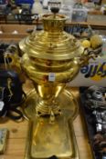 A large brass samovar with brass tray.