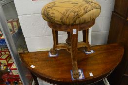 An oak framed revolving music seat.
