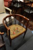An Edwardian inlaid mahogany horseshoe shaped occasional chair.